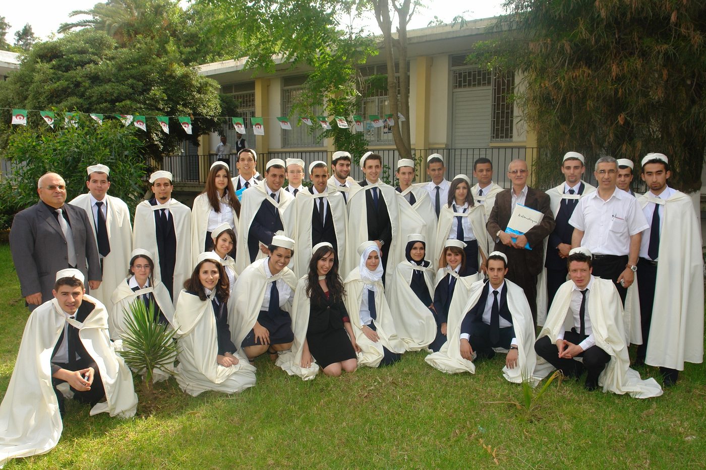 Une promotion d'étudiants en burnous traditionnel sur la pelouse du campus